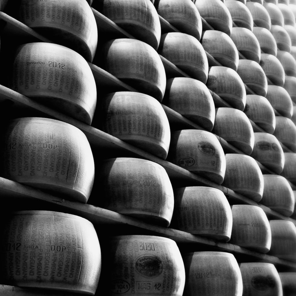 Rounds of Parmesan Cheese aging on racks