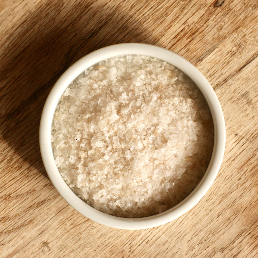 A white ramekin filled with smoked sea salt flakes