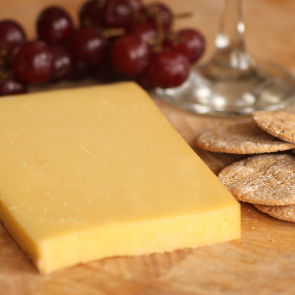 A piece of smoked Cheddar cheese on cheese board