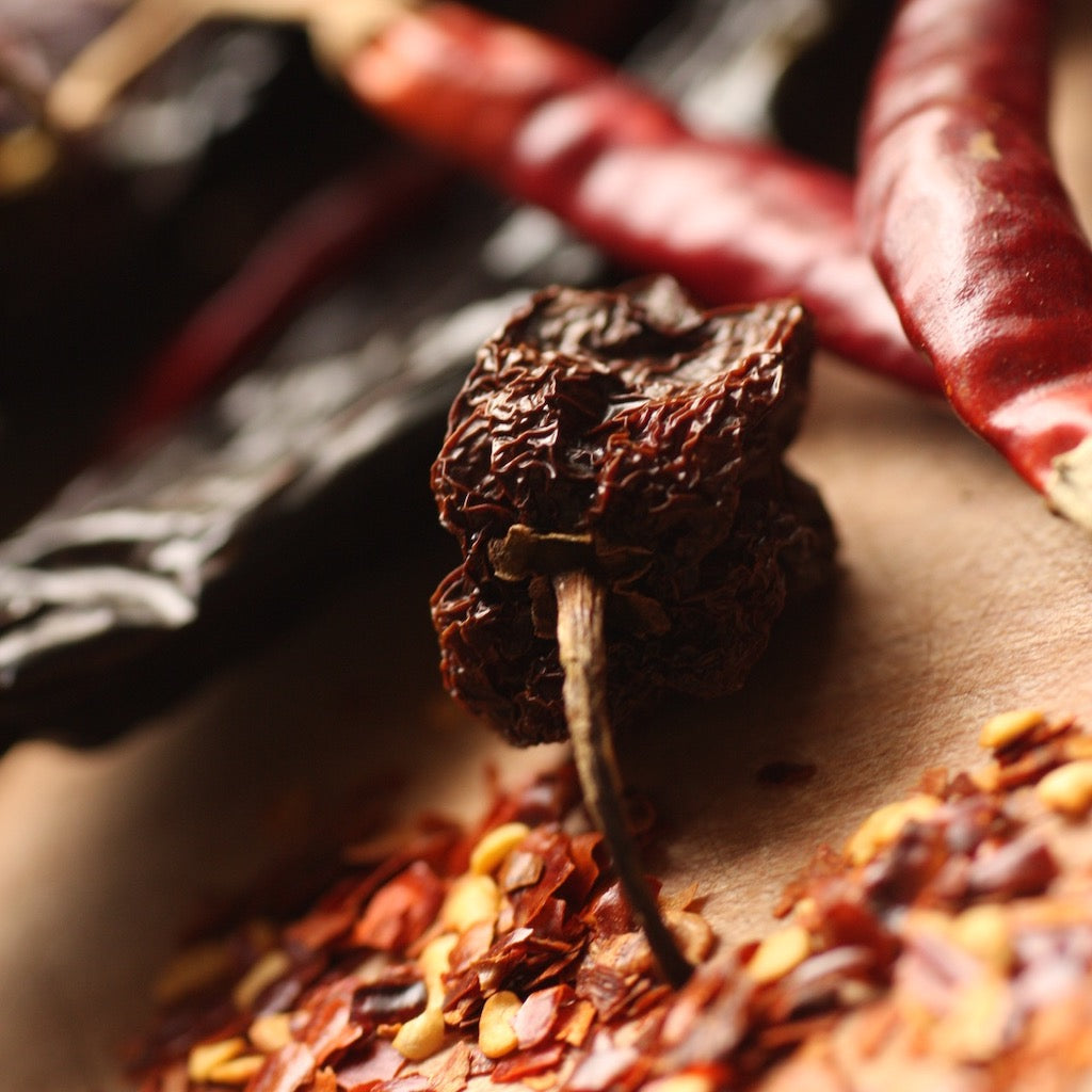 A selection of The Artisan Smokehouse's smoked & dried chillies on chopping board