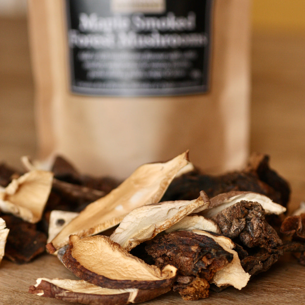 Dried smoked mushrooms on a wooden chopping board.