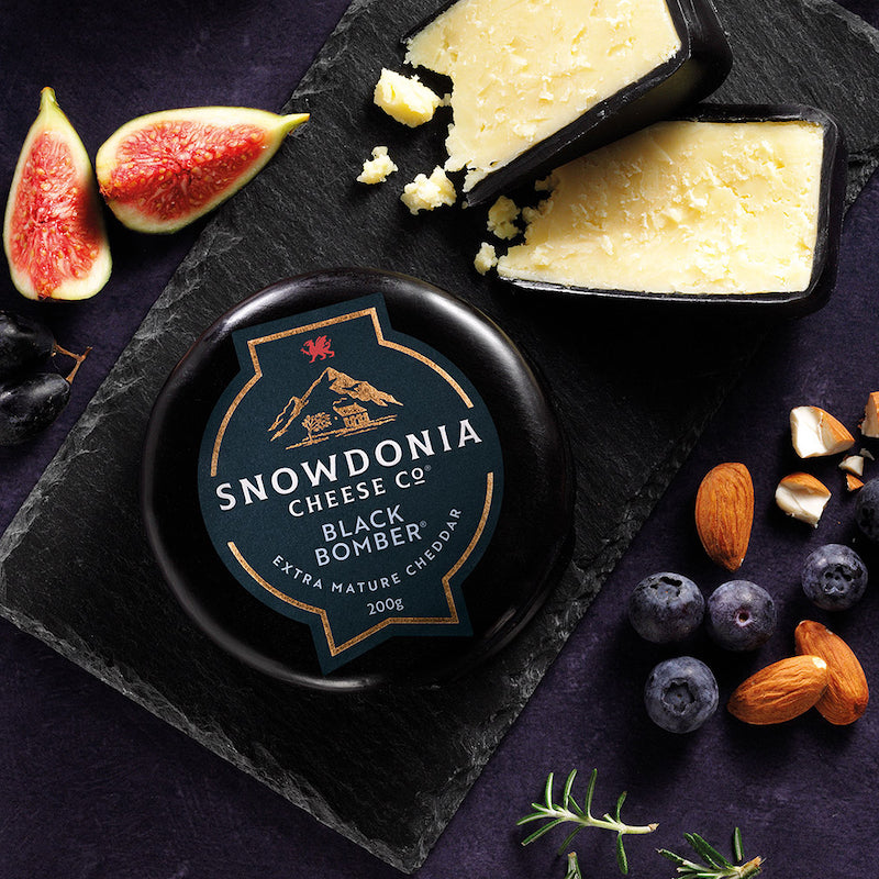 A Snowdonia Black Bomber on a cheese slate with figs