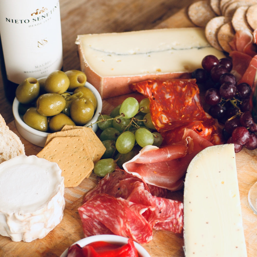 A platter of smoked foods with wine