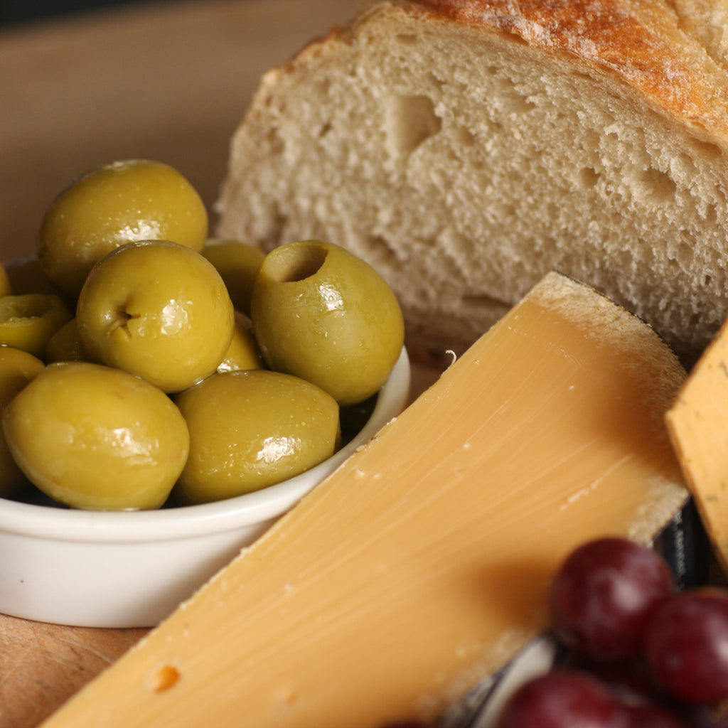 The Artisan Smokehouse's smoked olives on cheese board with cheese and bread