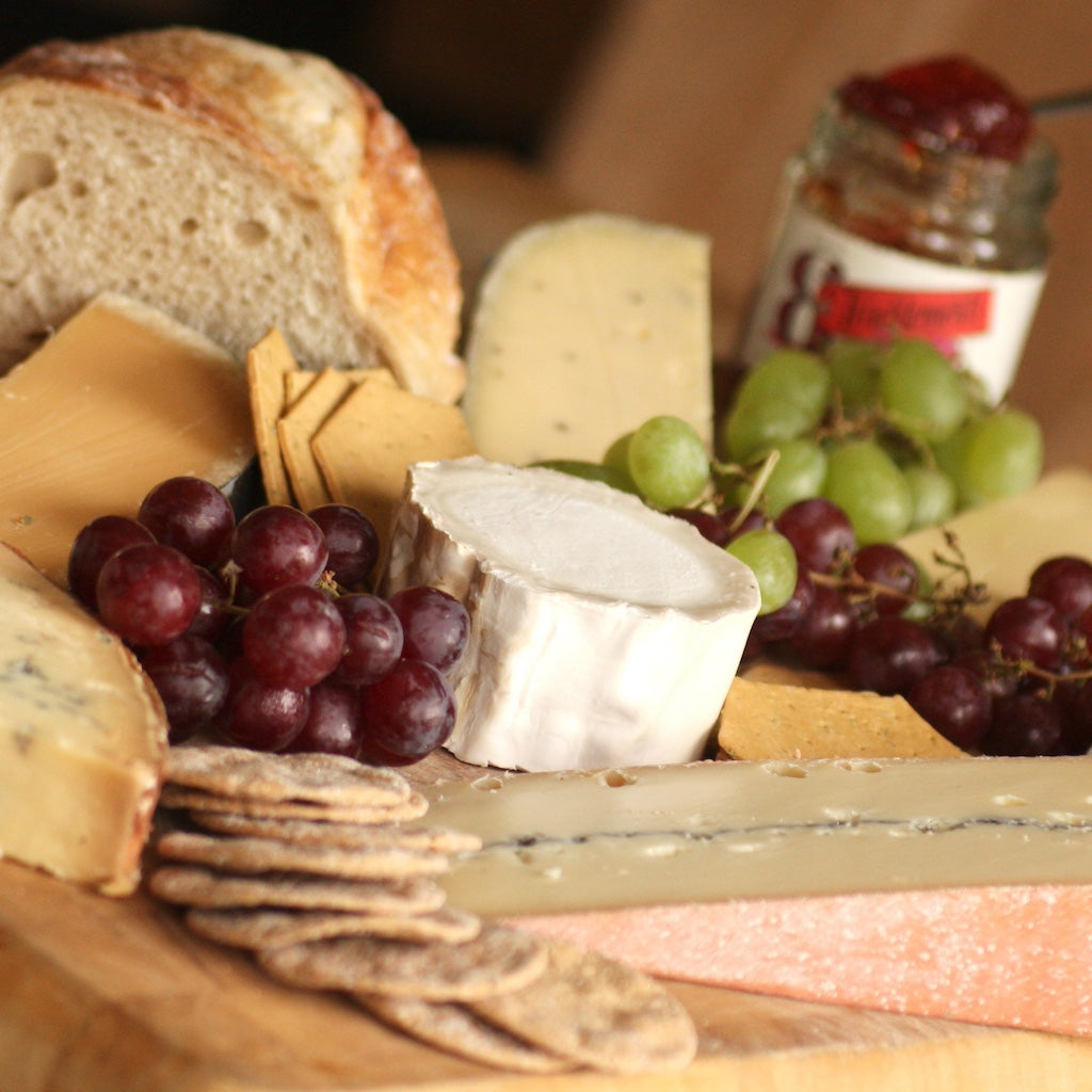 A cheese board of Artisan Smokehouse cheese, olives, grapes and chutney