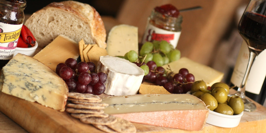 A cheese board of Artisan Smokehouse cheese, olives, grapes and chutney