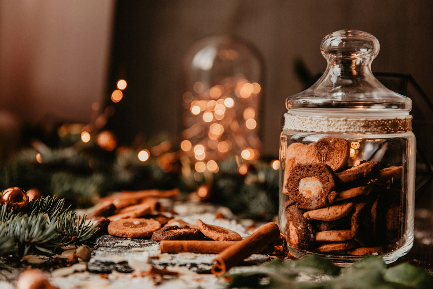 Glass jar filled with cookies on a festive table with blurred lights in the background