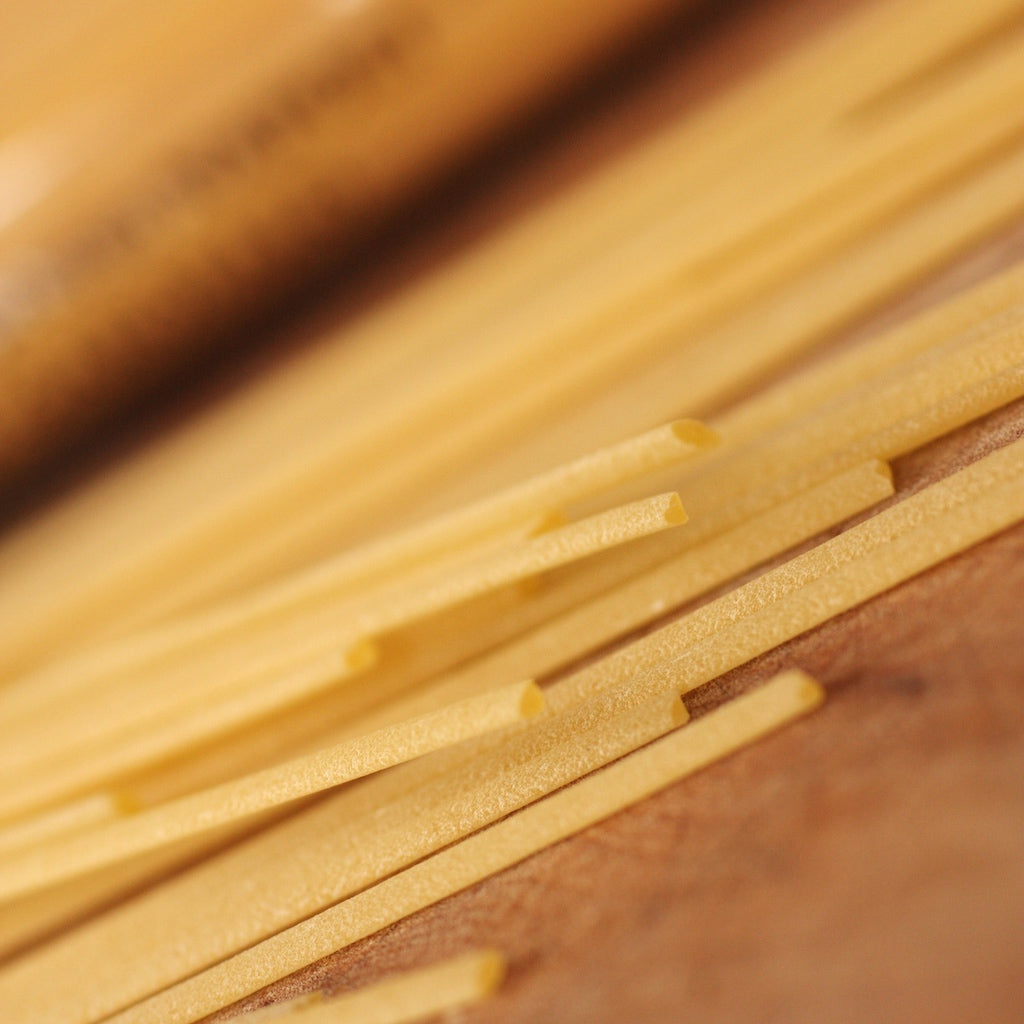 Dried linguine pasta on chopping board