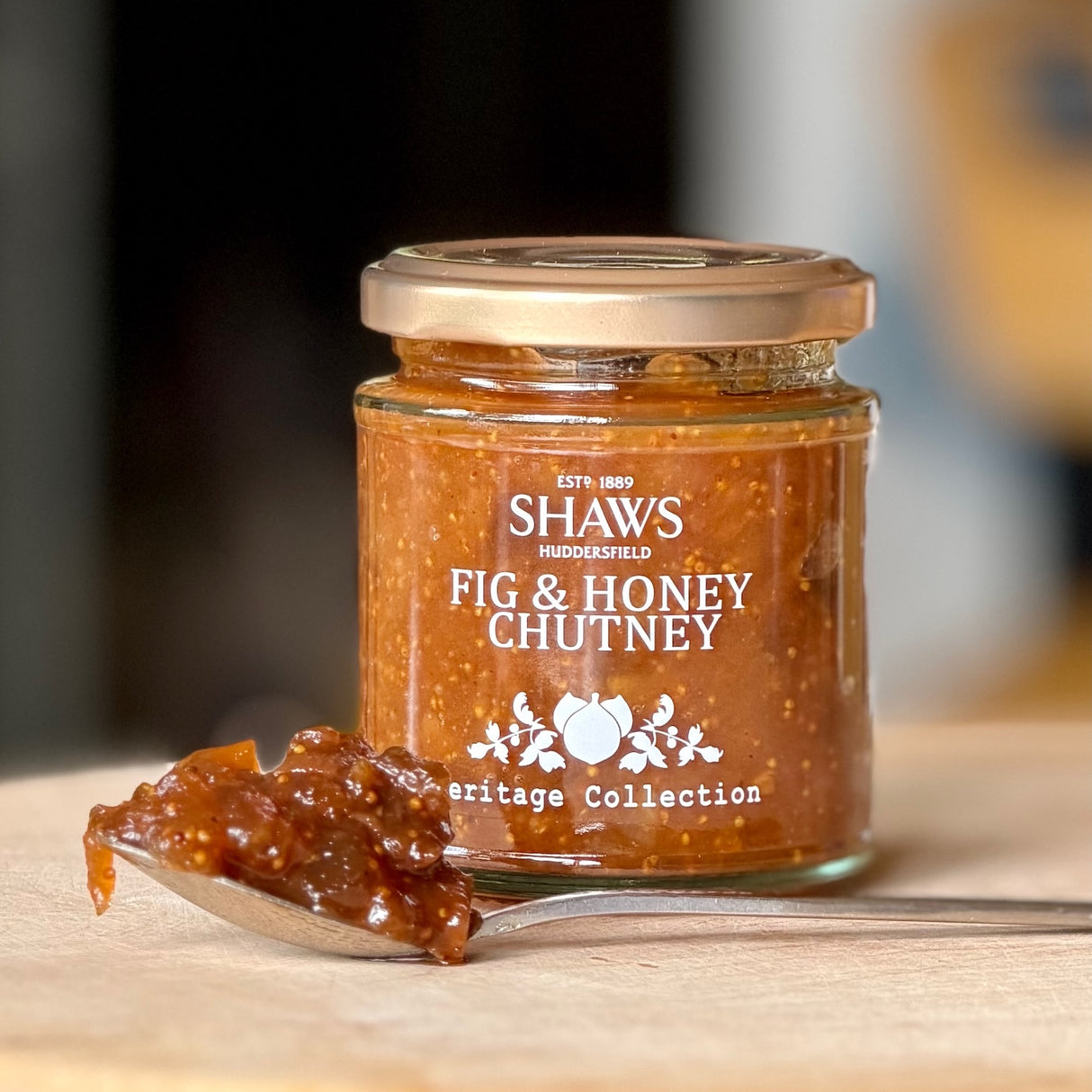 A jar of Shaws fig & honey chutney on a wooden board