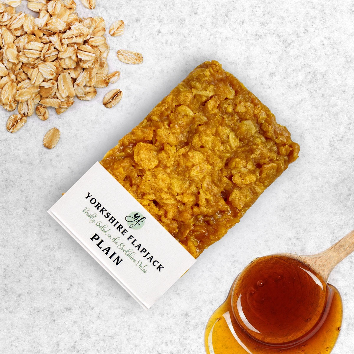 Yorkshire Flapjack with honey and oats on a textured surface