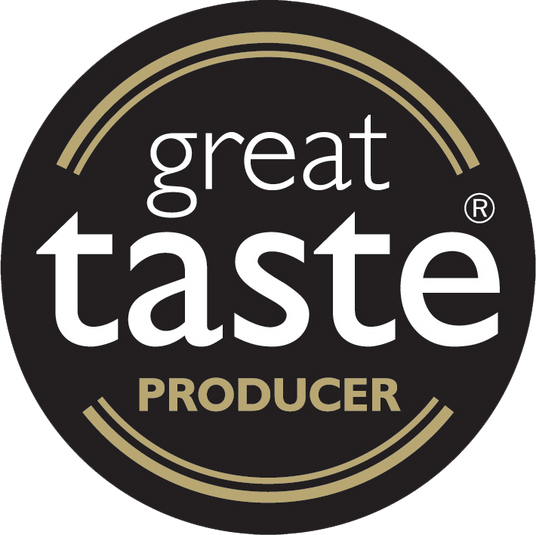 A circular black badge with the words 'great taste PRODUCER' in white and gold lettering for the great Taste Awards.