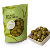 Green package of Garlic Marinade olives next to a bowl of olives on a white background