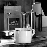 A cup of coffee next to a bag of Harris & James coffee