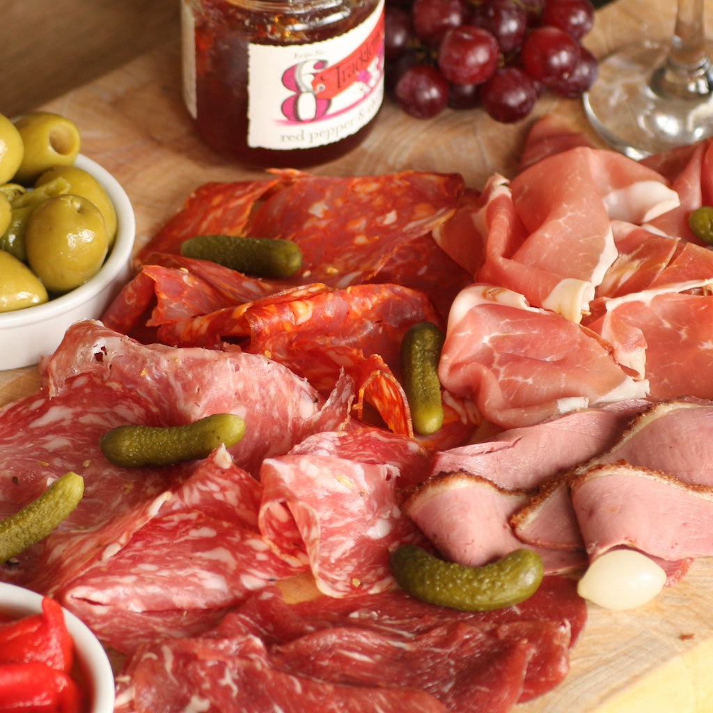 A platter of Artisan Smokehouse smoked meats with olives and bread