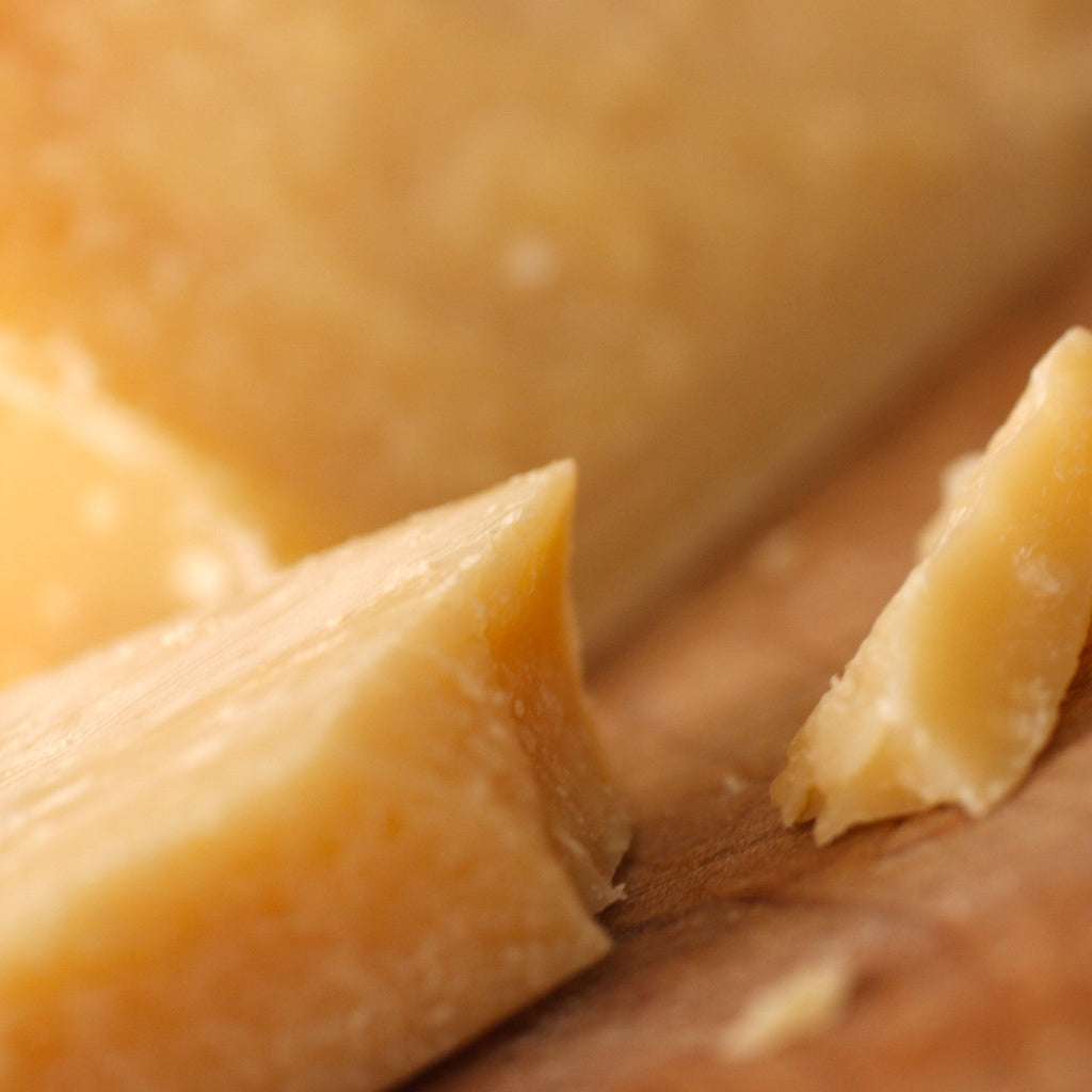 A chunk of Parmesan Cheese on chopping board