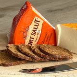 A piece of Port Salut with crackers and a cheese knife