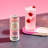 Can of Manchester Gin cocktail with a glass of pink cocktail with raspberries on a pink background