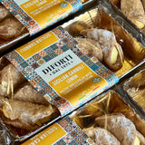 Packaged Sicilian cannoli pastries arranged in clear plastic trays. 