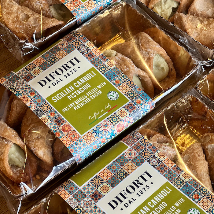 Packaged Sicilian pistachio cannoli with Diforti branding on a wooden surface.