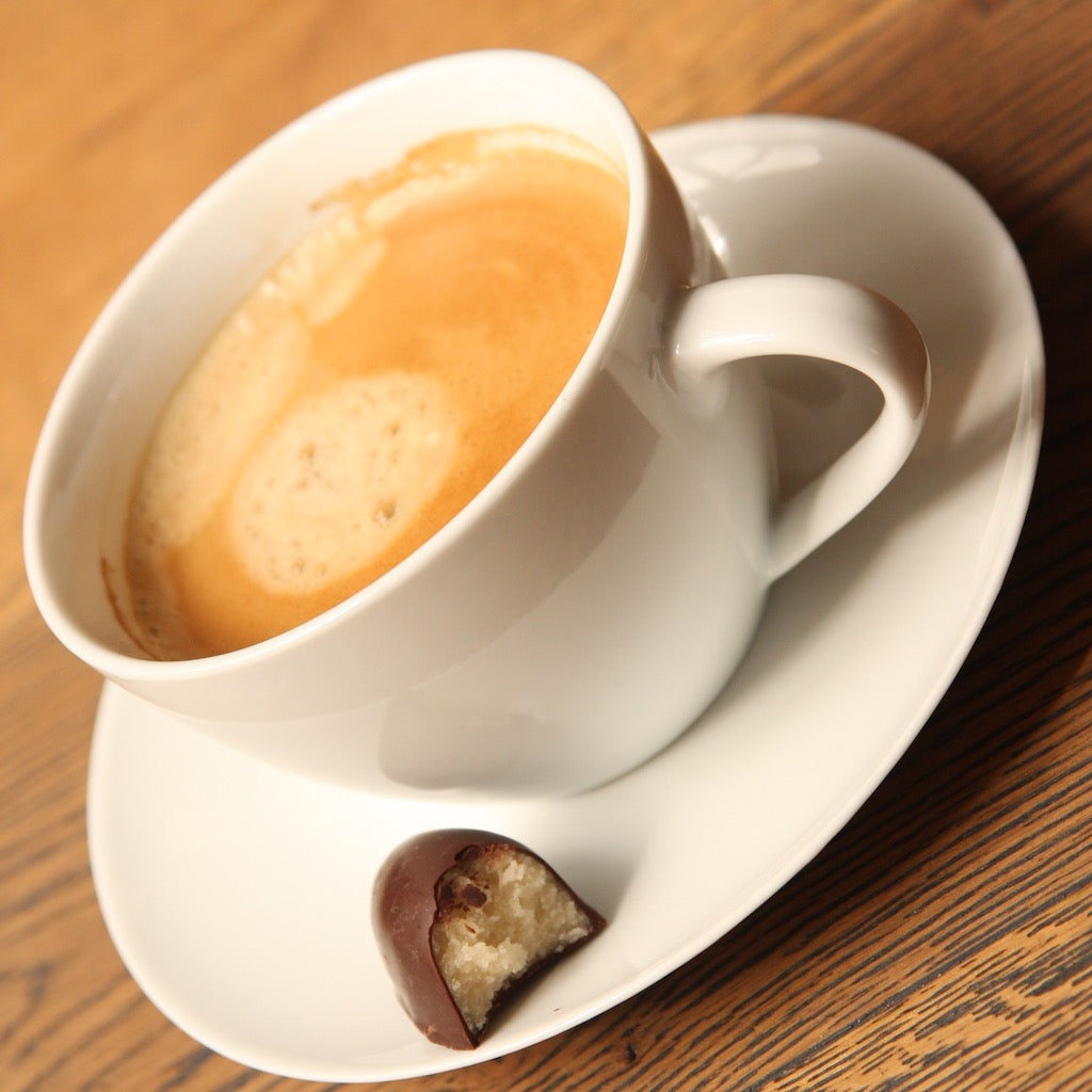 A cup of Coffeelink coffee with chocolate on saucer