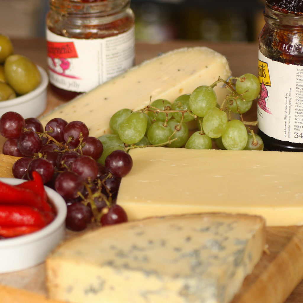 The Artisan Smokehouse's smoked mature Cheddar on cheese board with other cheeses, chutney and grapes