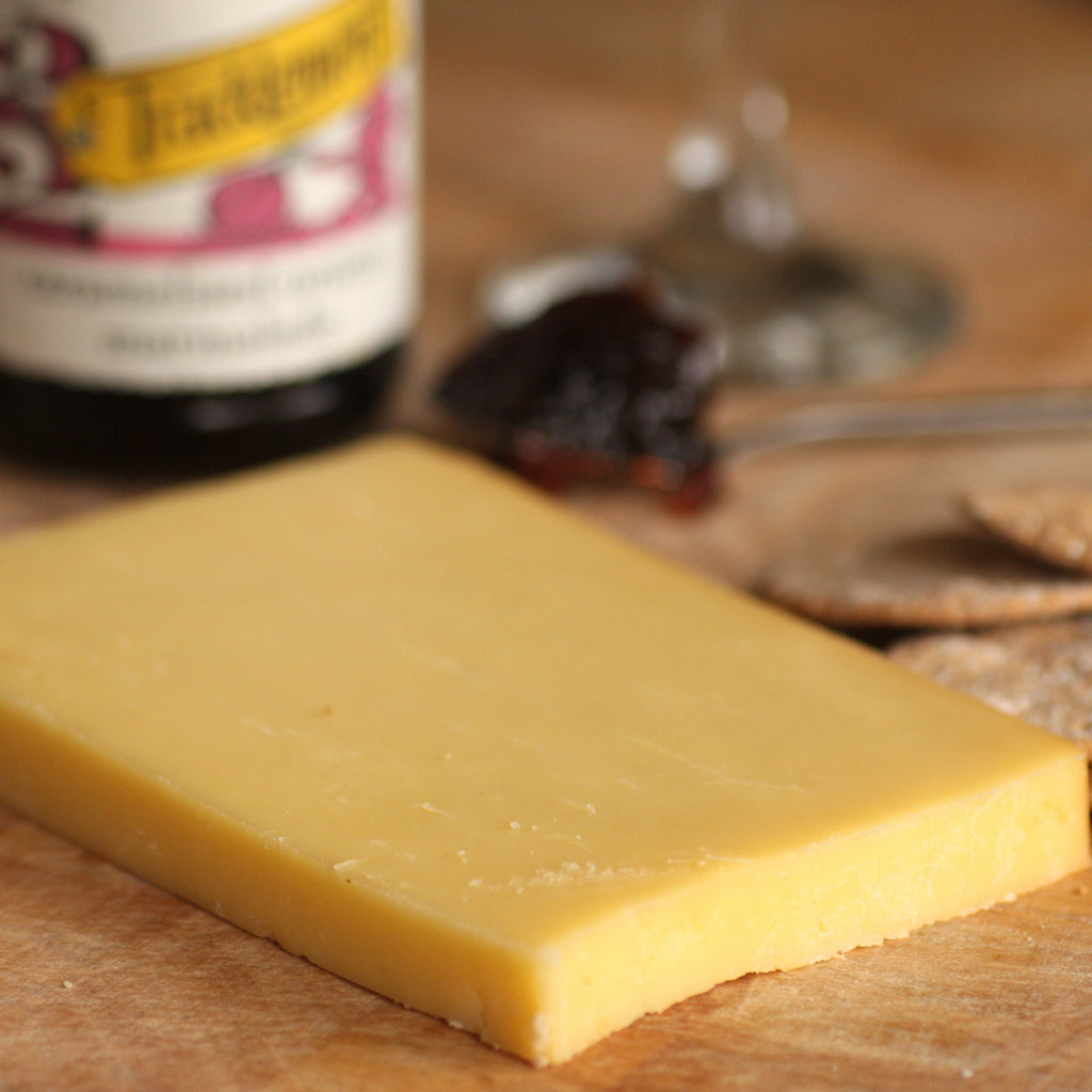 A piece of The Artisan Smokehouse's smoked mature Cheddar on cheese board with crackers and chutney
