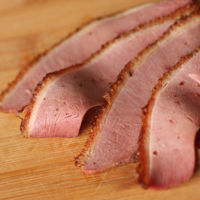 Slices of smoked duck on a wooden board
