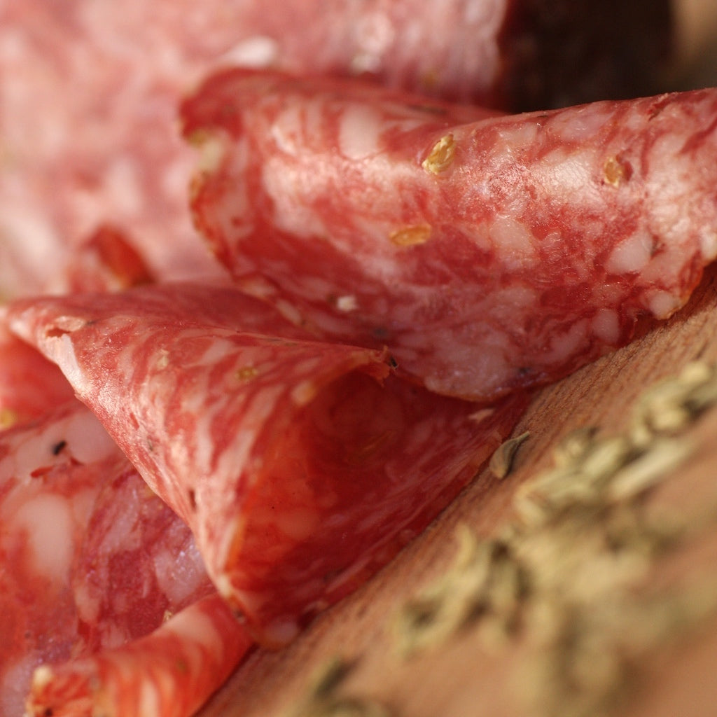 Smoked Finocchiona salami on board with fennel seeds