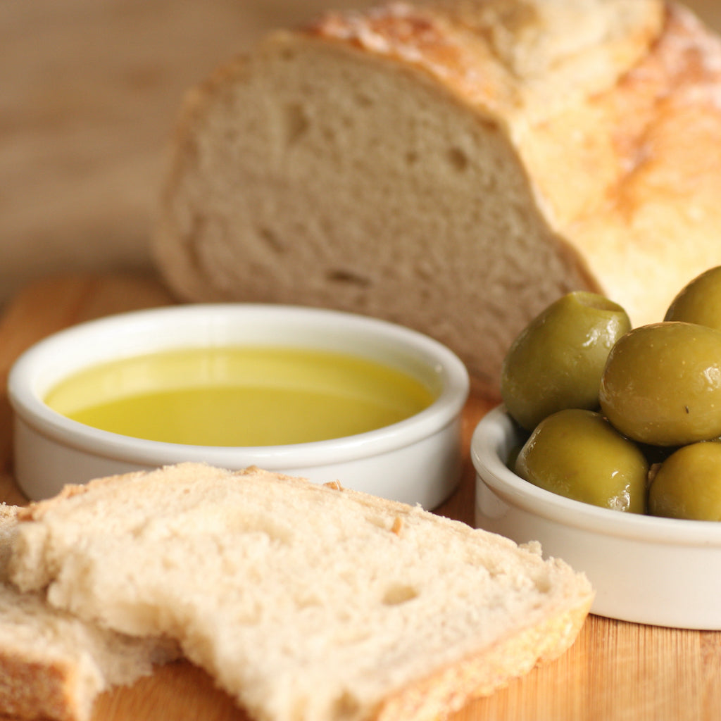 A ramekin of The Artisan Smokehouse's smoked Italian olive oil with dipping bread and smoked olives
