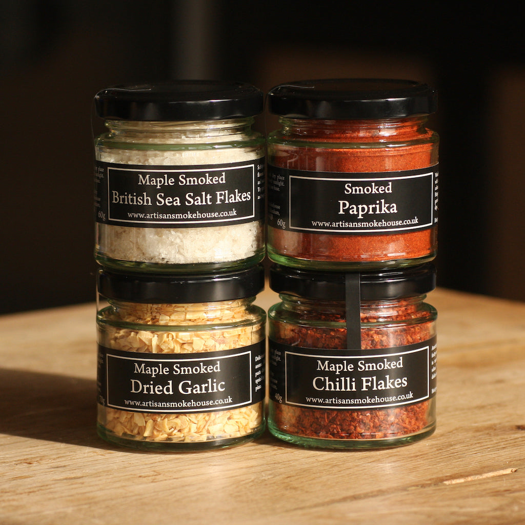 A jar of The Artisan Smokehouse's smoked chilli flakes with other jars of smoked spices