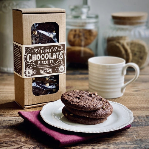Triple chocolate chip cookies on a plate with mug of tea