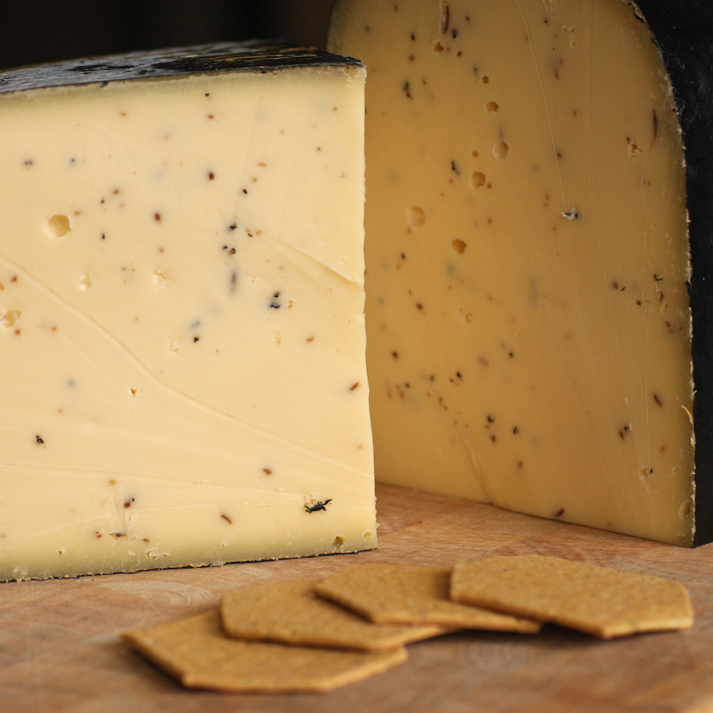 A chunk of truffle Gouda on cheese board with crackers
