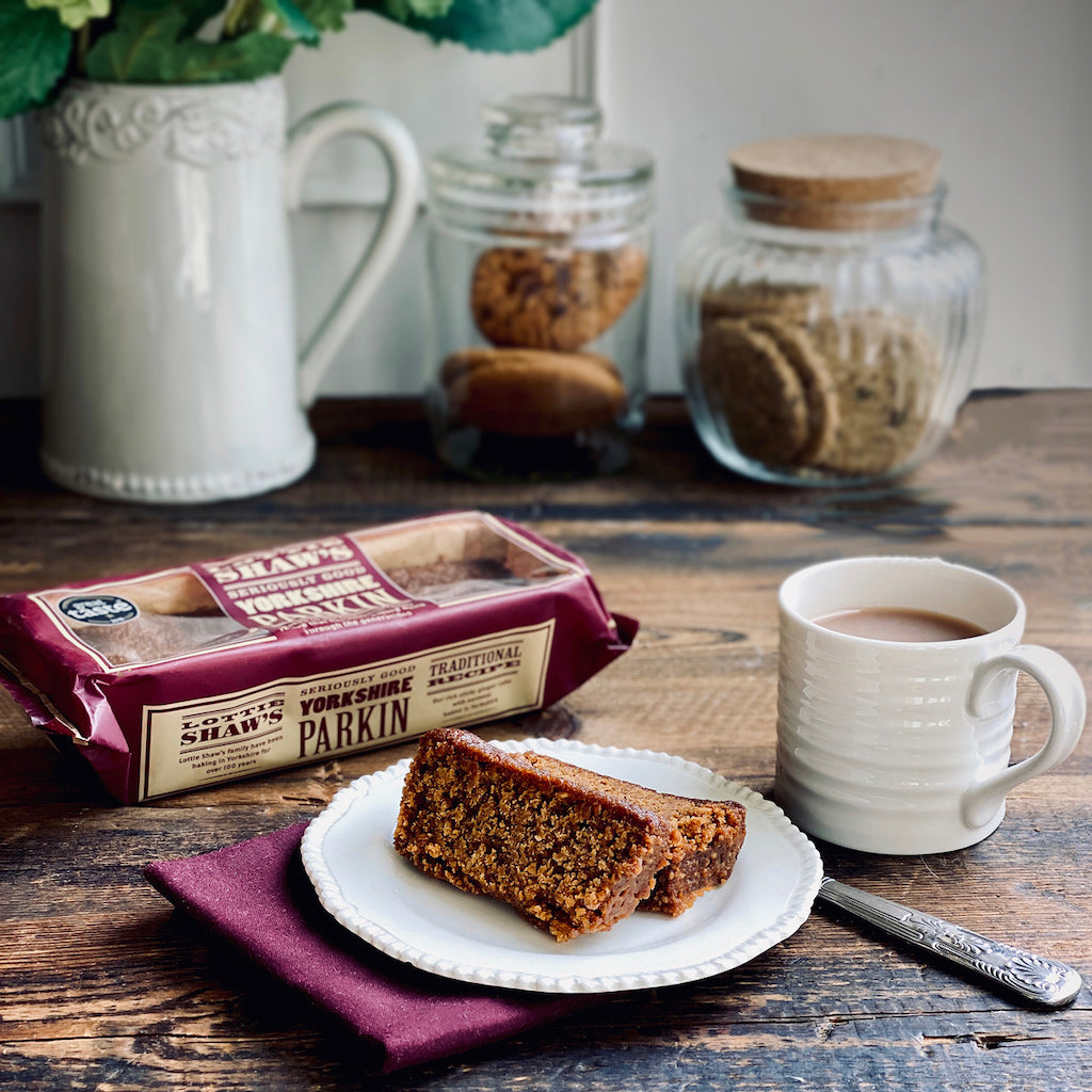 Two pieces of Yorkshire Parkin on plate with a mug of tea