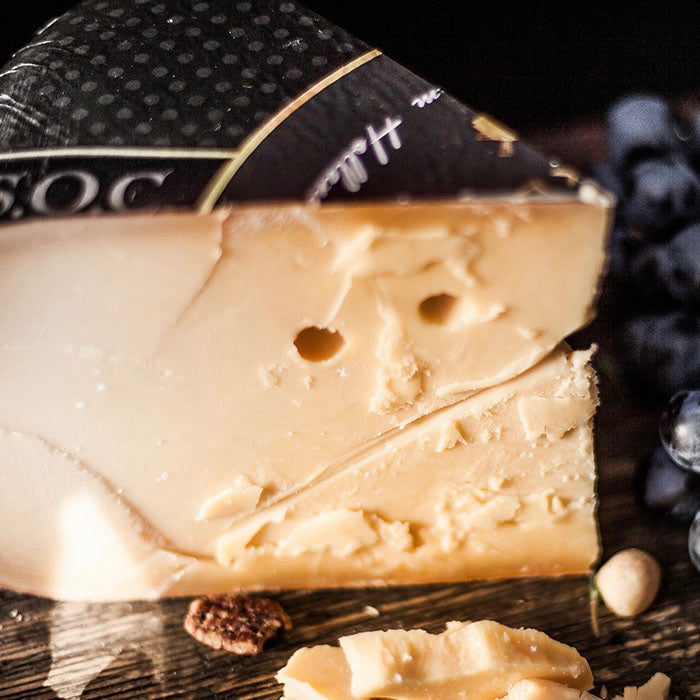 A piece of Weydeland VSOC Gouda on a wooden board